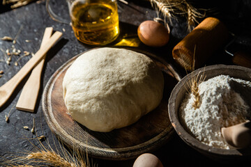 Dough on the table on a dark background.Flour,butter,eggs