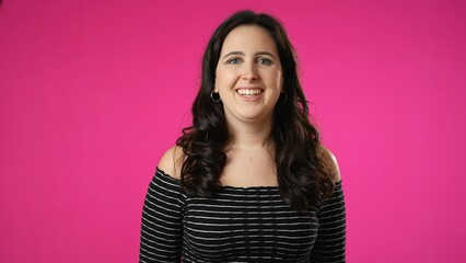 Smiling laughing beautiful brunette young woman 20s 30s years old posing isolated on pink background studio. People sincere emotions lifestyle concept. Looking at camera with charming smile