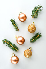 Christmas composition. Christmas glitter balls and natural spruce branches on gray background. Flat lay, top view, copy space. Vertical image.