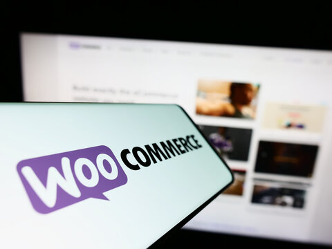 Stuttgart, Germany - 12-02-2022: Smartphone with logo of open-source e-commerce solution WooCommerce on screen in front of business website. Focus on center-left of phone display.
