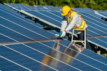 Renewable energy and solar to electricity concept. Asian senior man technician holding a drill to...