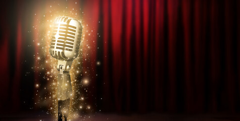 Silver vintage microphone on blurry red velvet stage curtains.