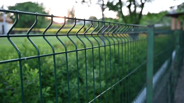 Slow walking along blurred fence in summer without people