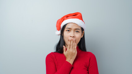 Pretty lovely lady asian thai women in red sweater and santa christmas hat isolated over grey background. thinking and surprise