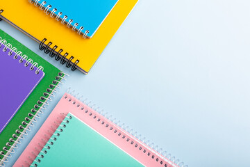 colored notebooks, colored pencils on a light table. Place for your text.