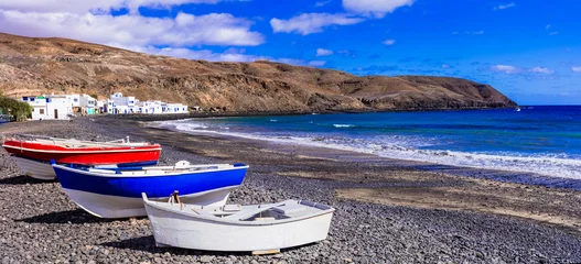 Behangcirkel Scenic places of Fuerteventura island. Charming fishing village Pozo Negro with colorful old boats on the beach. Canary islands © Freesurf