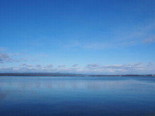 Calm, blue winter bay and blue sky