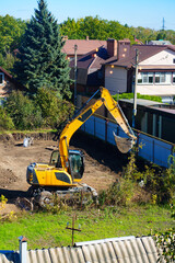 An excavator digs the ground on the construction site 