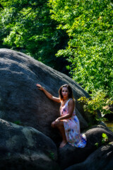 Photographs of model in nature relaxing on large rock