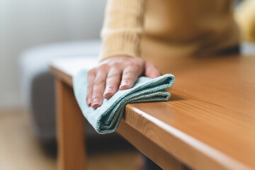 happy Female housekeeper service worker wiping table surface by cleaner product to clean dust.