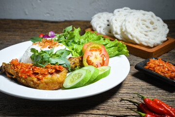 Ayam geprek sambal indonesian food or geprek fried chicken with sambal hot chili sauce served steam rice on white plate