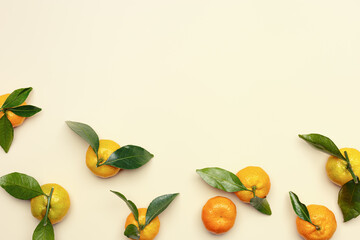 Ripe fresh orange yellow tangerines with green leaves on pastel beige table background with copy space. Citrus fruit mandarines as food background, empty space, still life aesthetic photo