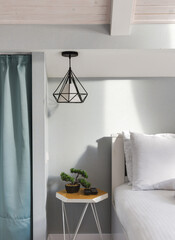 Bright bedroom interior with designer table and loft-style lamp. close up
