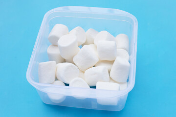 Delicious white marshmallows on blue background.