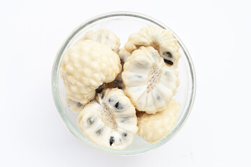 Custard apple in glass bowl on white background.