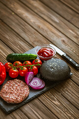 From above view of ingredients for beef black burger on a black stone board. Delicious food 