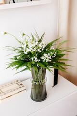 green flower bouquet in green vase in living room interior, minimalistic bouquet on white table, greeting bouquet for her, florist 
