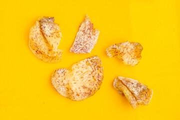 Crispy taro chips on yellow background.