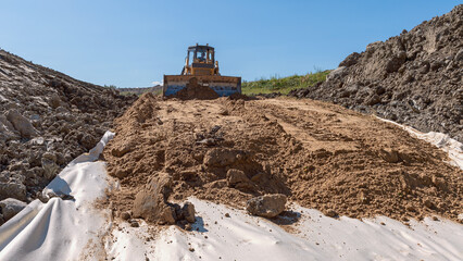 the process of leveling sand with a modern bulldozer during the construction of a dirt road