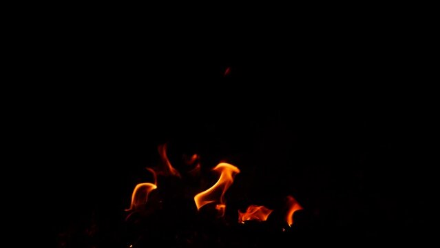 Fire burning lowly in darkness yellow flame effect