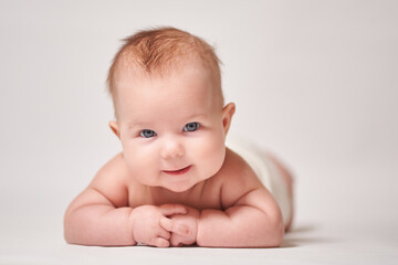 portrait of a smiling baby on a white background looking into the camera