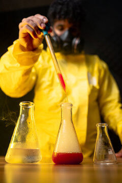 Male chemist adding reagent into flask