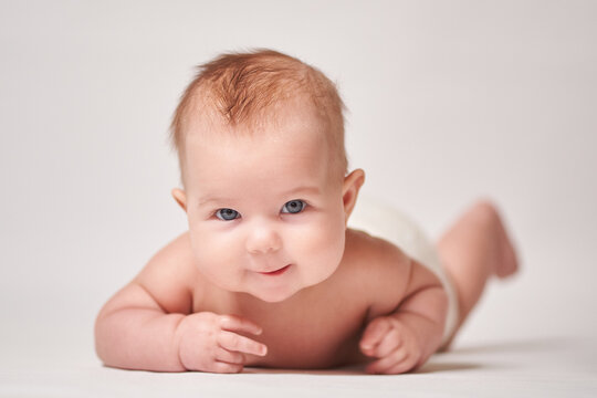 portrait of a smiling baby on a white background looking into the camera