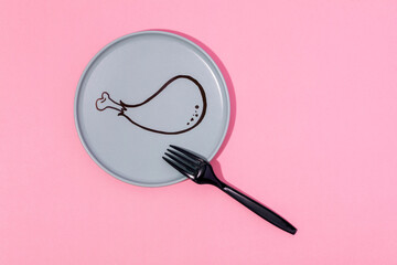 Plate with painted cartoon chicken leg and fork served on pink surface