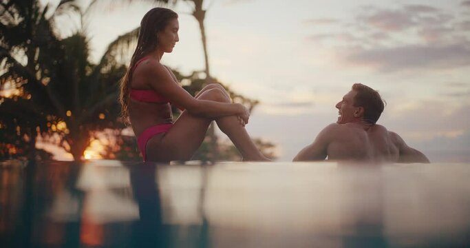Attractive couple relaxing in tropical infinity pool at luxury resort spa on vacation