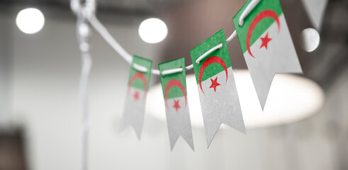 A garland of Algeria national flags on an abstract blurred background