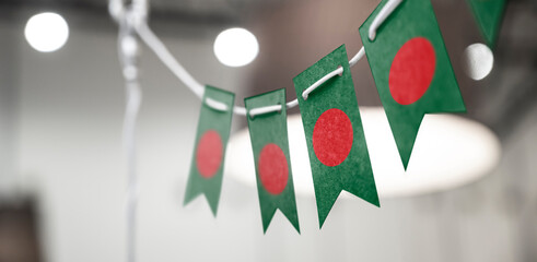 A garland of Bangladesh national flags on an abstract blurred background