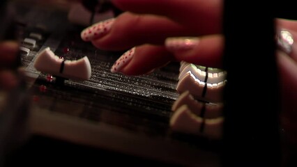 Female Hand on Mixing Console in Studio. Close Up. 4K Resolution.