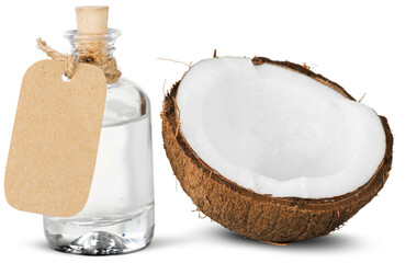 Liquid coconut oil and halved coco-nut on table.