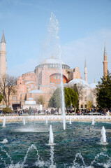 Fototapeta na wymiar Hagia Sophia -Ayasofya museum and fountain view from the Sultan Ahmet Park in Istanbul, Turkey. It is in use as a church, mosque and museum.