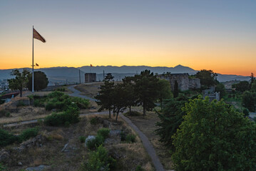 Wieża twierdzy z flaga narodową. Ruiny zamku z widokiem na Skopje o zachodzie słońca © smoku7979