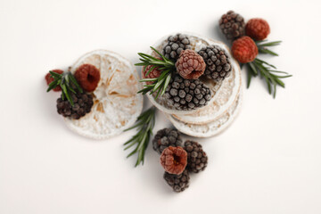 sweet delicious berry dessert of white dried oranges garnished with juicy raspberries and blackberries and rosemary sprigs on a white background. for signboards, labels, postcards, leaflets, shop bann