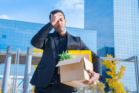 Man Fired From His Job Unemployment Concept. Dismissed Employee Carrying Cardboard Box With Office Stuff 