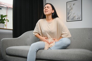 Menstrual pain, woman with stomachache suffering from pms at home, endometriosis, cystitis and...