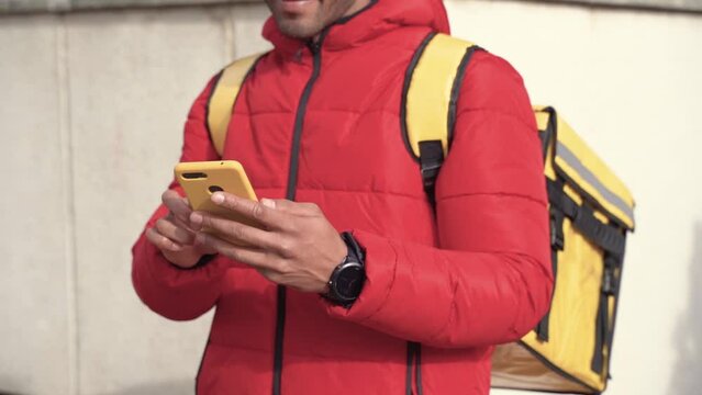 unrecognizable food delivery man restaurant food shipping checking customer address on his phone