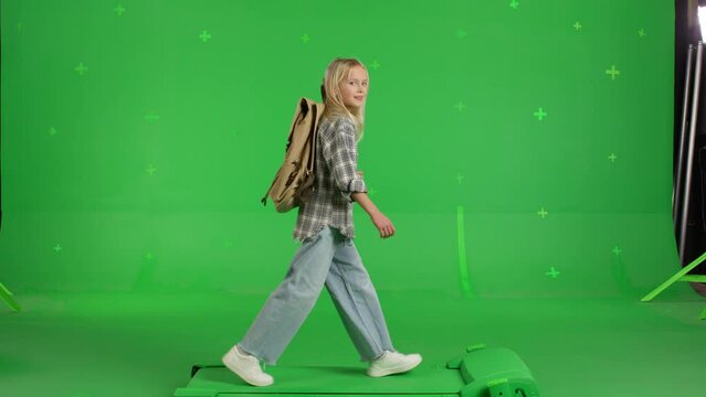 happy Caucasian child with backpack walking to school on a Green Screen, Chroma Key. 4k UHD side view video.