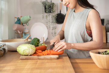 An Asian young woman cooking , preparing breakfast with healthy food in kitchen at home , healthy lifestyle