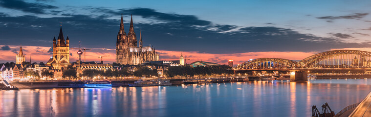 Cityscape night panoramic view of illuminated Cologne or Koln city with Cathedral Dom and bridge...