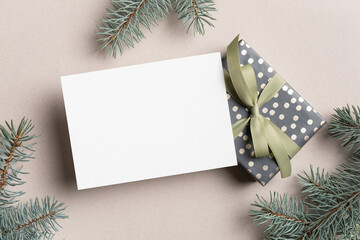 Greeting card mockup with christmas gift box and fir tree branches
