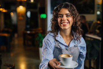 Waitress bring coffee and looks at the camera