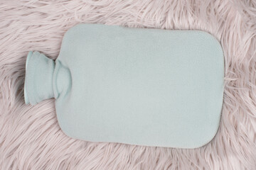 Hot water bottle on a fur, freezing winter, keep warm, high energy costs

