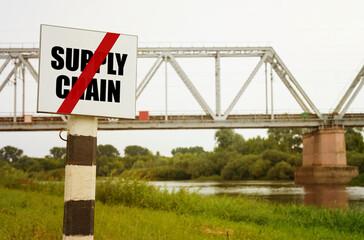 Obraz premium On the background of the railway bridge there is a sign with the inscription - NO SUPPLY CHAIN