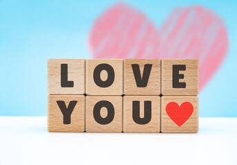 love you written on wooden cube blocks on blue background. love day concept
