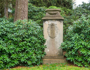 Alter Grabstein mit einer Pflanzschale und schönen Ornamenten  auf einem Friedhof in Hamburg
