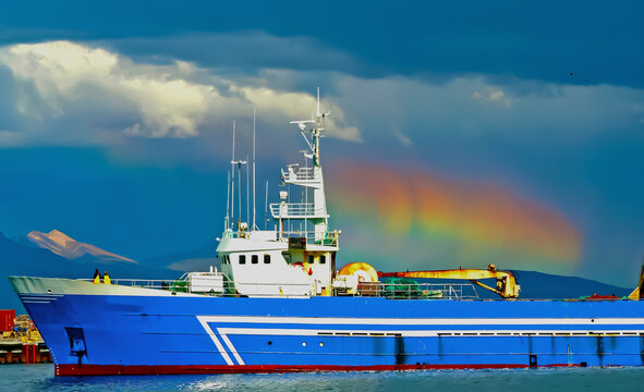 Cargo ship in harbor of iceland, spectacular circumhorizontal arc optical halo phenomenon "fire rainbow", storm clouds over mountains - Reykjavik, Iceland