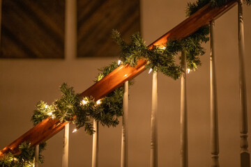 Garland and lights wrapped around handrail on stairs for Christmas 